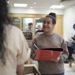 Volunteer worker smiling while holding a clipboard and pen