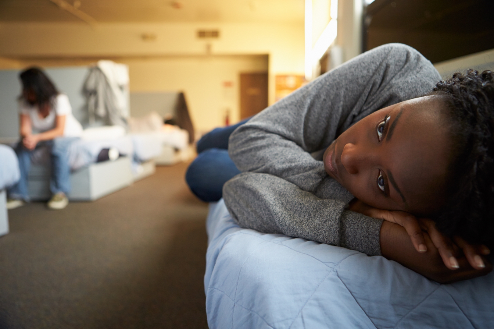 Women Lying On Beds In Homeless Shelter