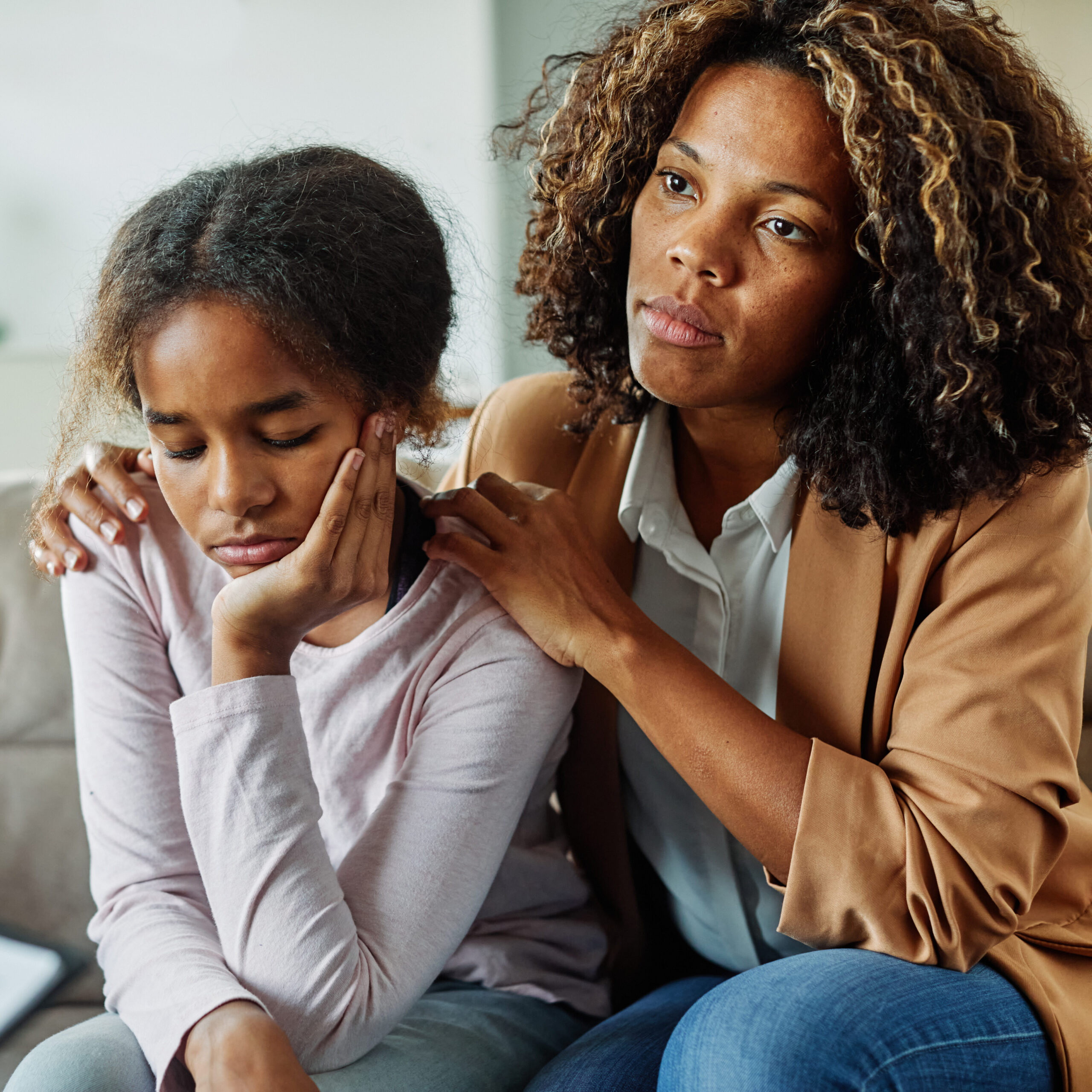 Mother with her teenage daughter at meeting with social worker, psychologist discussing mental health family sitting on sofa in psychotherapist office